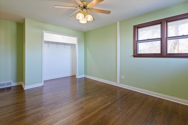 unfurnished bedroom with a closet, ceiling fan, and dark wood-type flooring