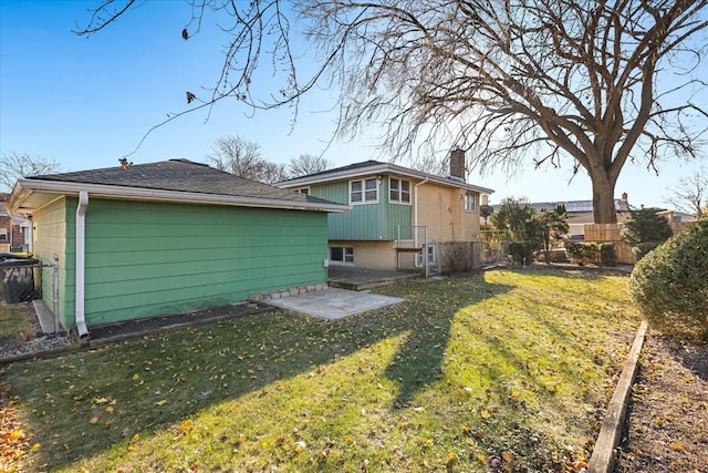 rear view of house featuring a lawn