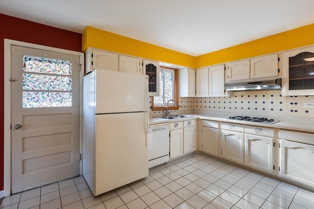 kitchen featuring light tile patterned floors, white appliances, backsplash, and sink