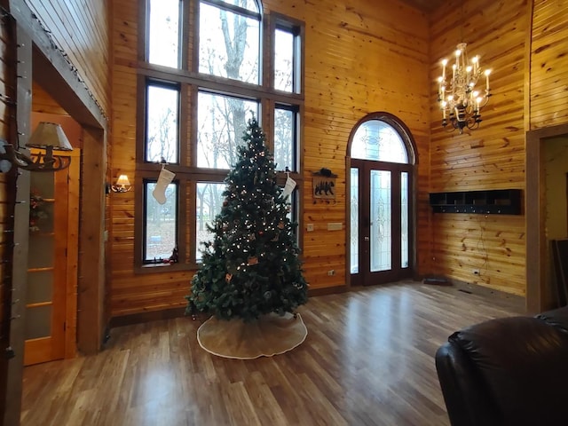 doorway to outside with a high ceiling and wooden walls