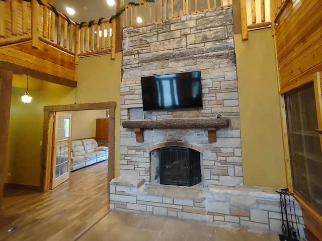 living room with a towering ceiling and a stone fireplace