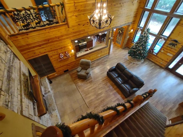 living room featuring an inviting chandelier, a towering ceiling, and wood-type flooring