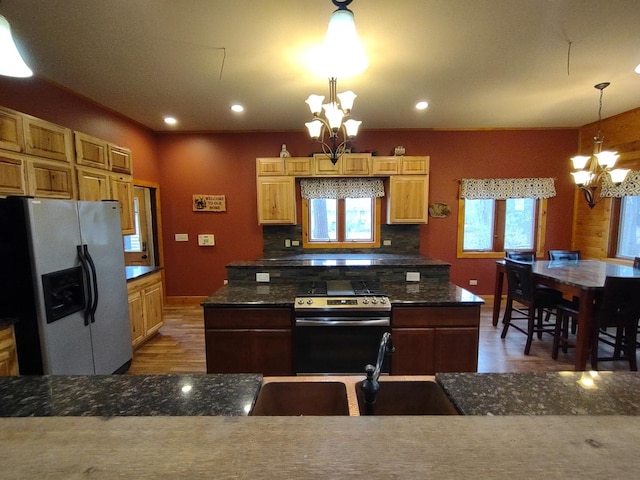 kitchen featuring hardwood / wood-style floors, stainless steel appliances, tasteful backsplash, hanging light fixtures, and a chandelier