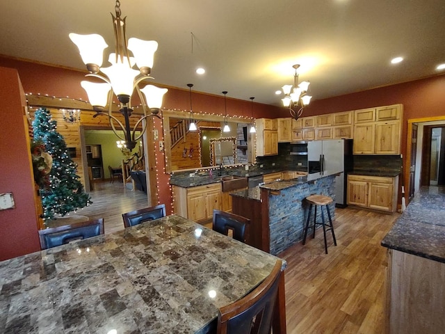 kitchen featuring a kitchen bar, appliances with stainless steel finishes, a chandelier, and a kitchen island