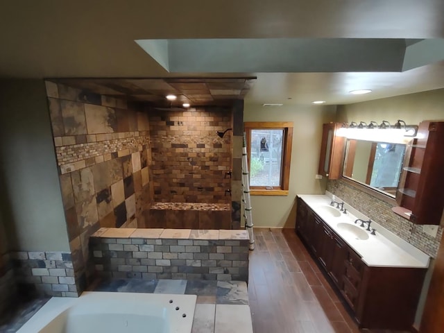 bathroom with hardwood / wood-style floors, vanity, and a tile shower