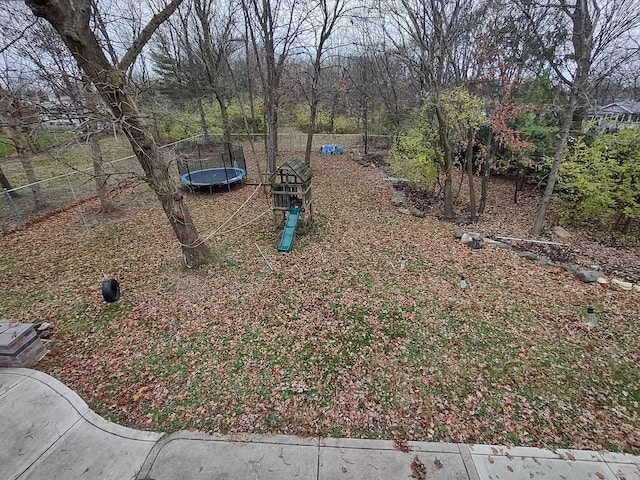 view of yard with a playground and a trampoline