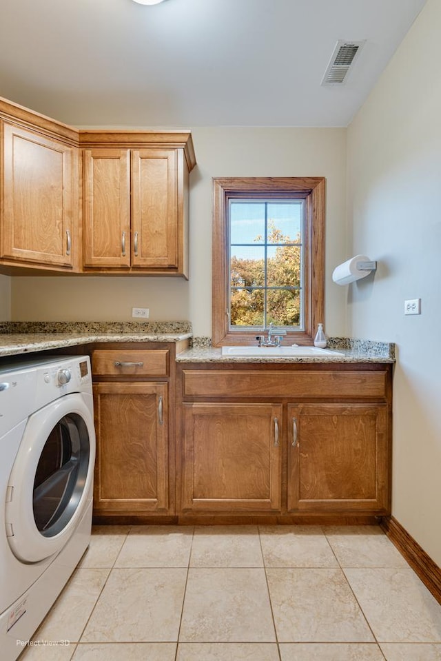 laundry area with cabinets, washer / dryer, sink, and light tile patterned floors