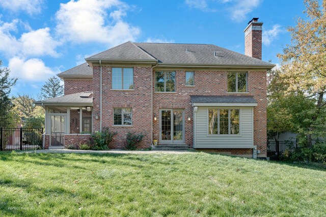 back of house featuring a yard and a sunroom