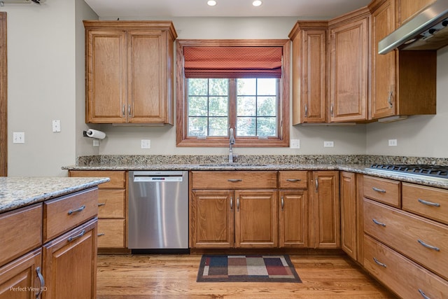 kitchen featuring stainless steel appliances, light stone countertops, sink, and light wood-type flooring