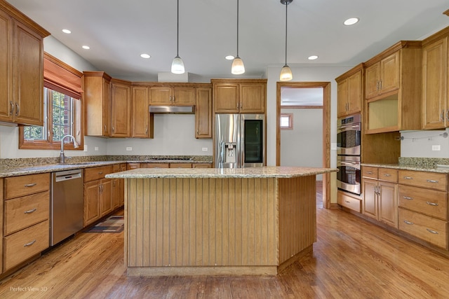 kitchen with sink, decorative light fixtures, a center island, and appliances with stainless steel finishes