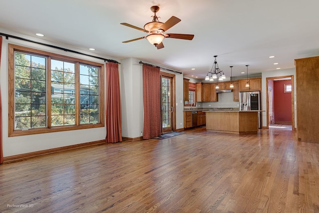 unfurnished living room featuring ceiling fan and wood-type flooring