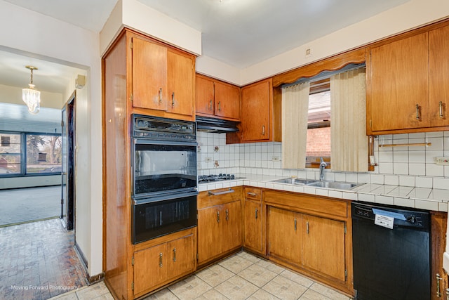 kitchen featuring black appliances, decorative backsplash, a healthy amount of sunlight, and sink