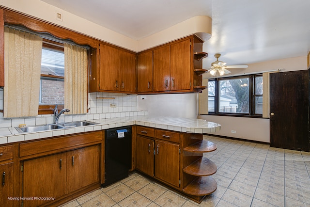 kitchen featuring sink, ceiling fan, decorative backsplash, black dishwasher, and tile counters