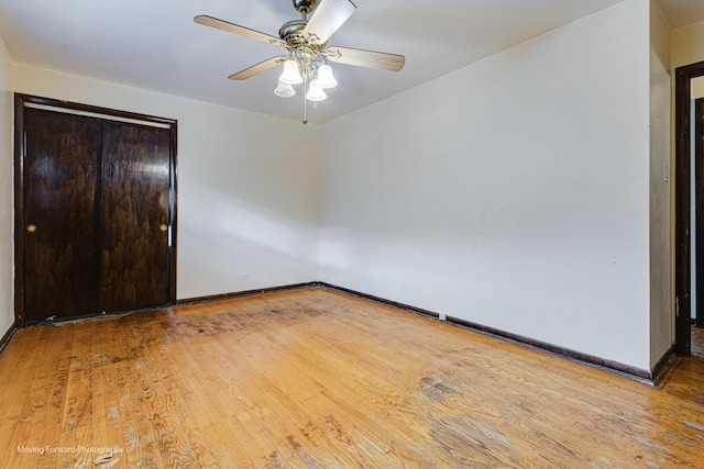 unfurnished bedroom with hardwood / wood-style flooring, ceiling fan, and a closet