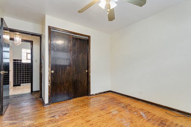 unfurnished bedroom with hardwood / wood-style flooring, a closet, and ceiling fan