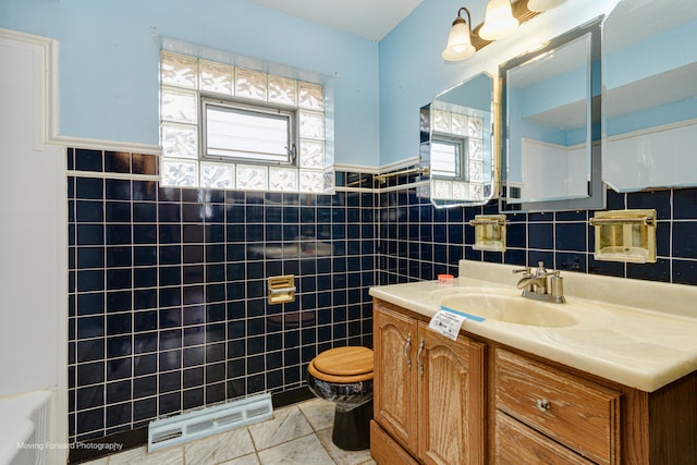 bathroom featuring tile patterned flooring, vanity, toilet, and tile walls