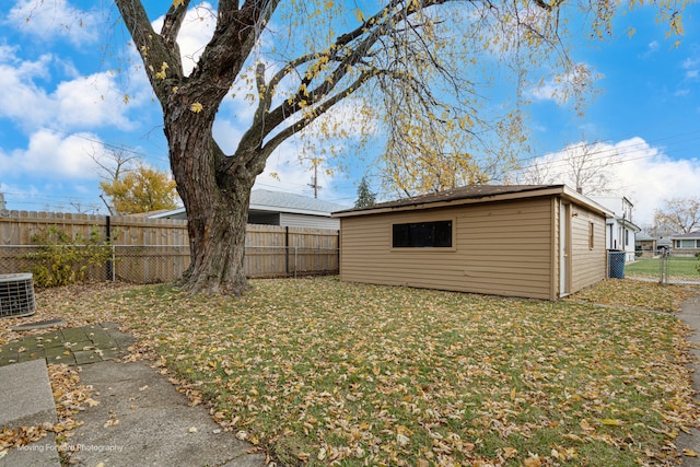 view of yard with central AC unit and an outbuilding