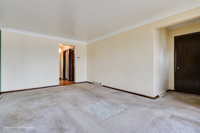 spare room featuring crown molding and light carpet