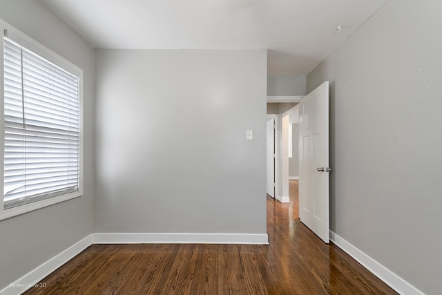 unfurnished room featuring dark hardwood / wood-style floors and plenty of natural light