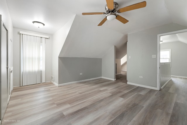 additional living space featuring lofted ceiling, ceiling fan, and light wood-type flooring