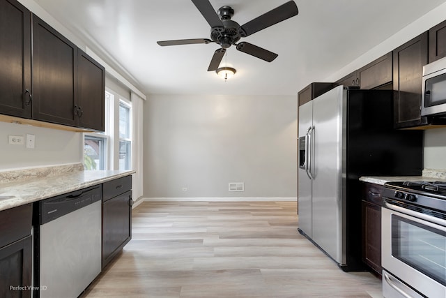 kitchen with ceiling fan, light stone countertops, light wood-type flooring, dark brown cabinetry, and stainless steel appliances