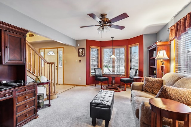 carpeted living room featuring ceiling fan with notable chandelier