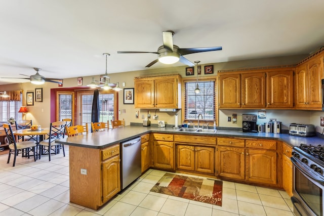 kitchen with kitchen peninsula, appliances with stainless steel finishes, plenty of natural light, and sink