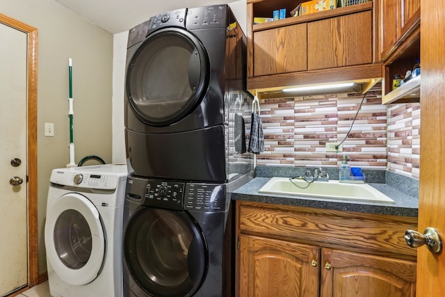 washroom with stacked washer / dryer, sink, and cabinets