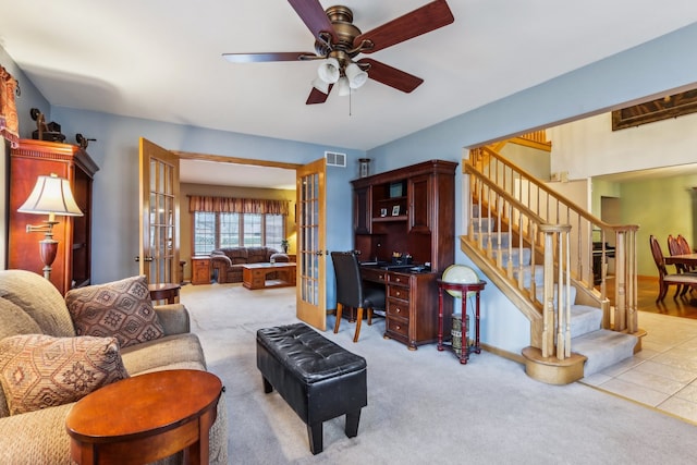 carpeted living room with ceiling fan and french doors