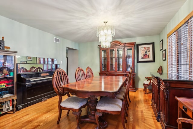 dining area featuring light hardwood / wood-style floors and a notable chandelier