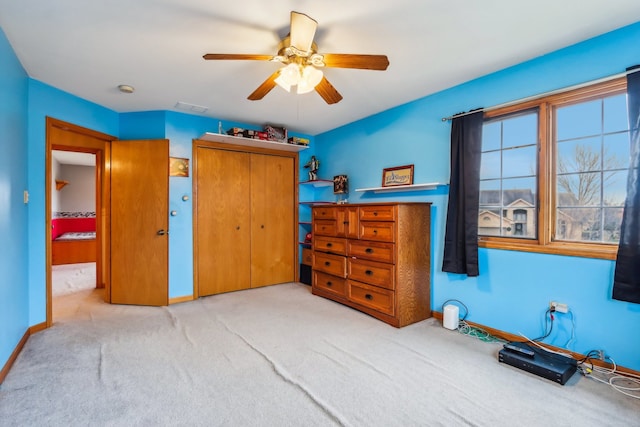 carpeted bedroom with ceiling fan and a closet