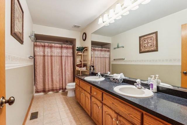 bathroom with tile patterned flooring, vanity, and toilet