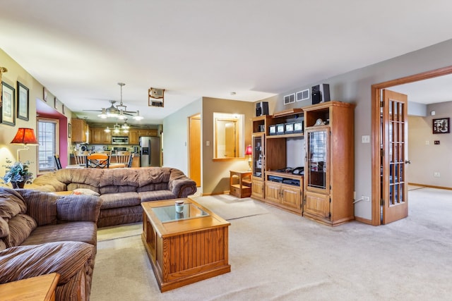 carpeted living room with ceiling fan