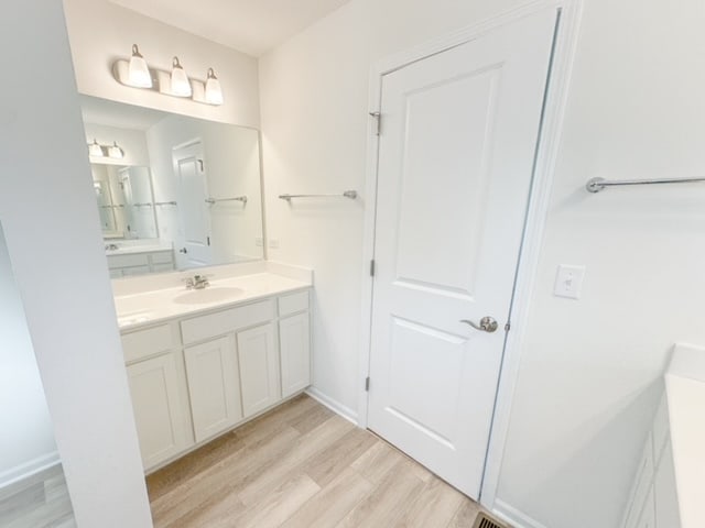 bathroom with hardwood / wood-style flooring and vanity