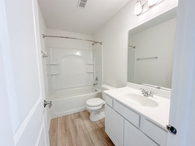 full bathroom featuring vanity,  shower combination, toilet, and wood-type flooring