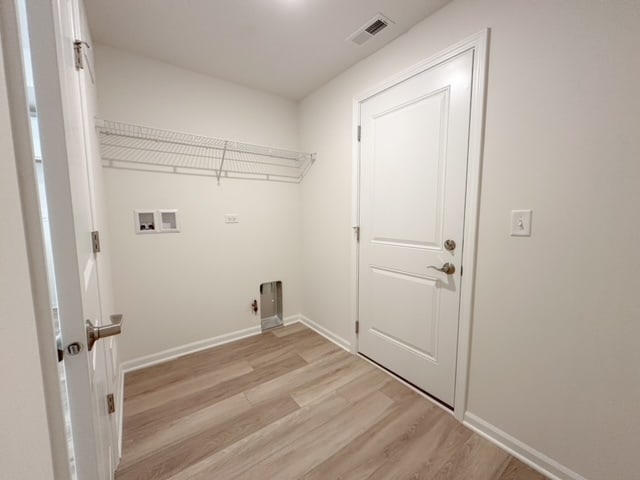 washroom featuring hookup for an electric dryer, washer hookup, and light hardwood / wood-style flooring