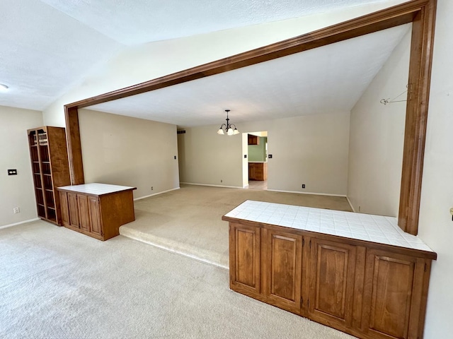 carpeted living room featuring a notable chandelier and vaulted ceiling