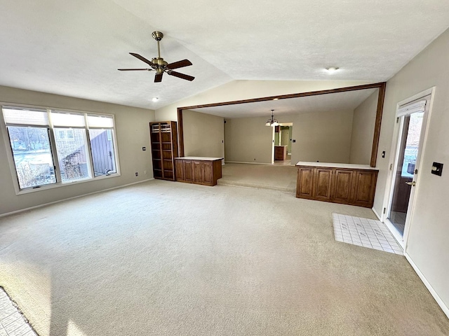 unfurnished living room with light carpet, vaulted ceiling, and ceiling fan