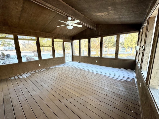 unfurnished sunroom featuring vaulted ceiling with beams, ceiling fan, a healthy amount of sunlight, and wood ceiling