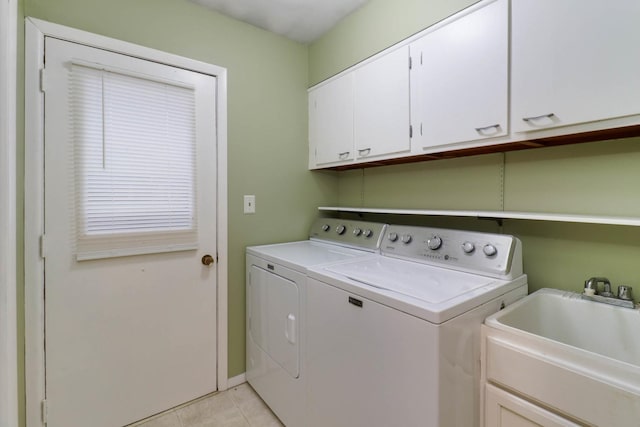 washroom featuring washing machine and clothes dryer, sink, light tile patterned flooring, and cabinets