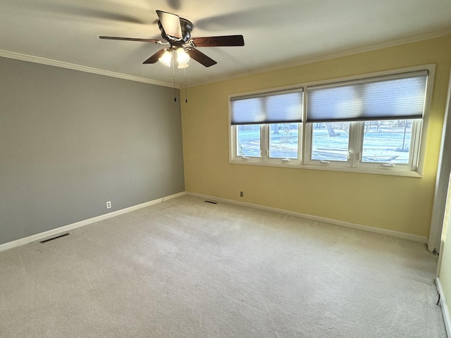 carpeted empty room with ceiling fan and crown molding