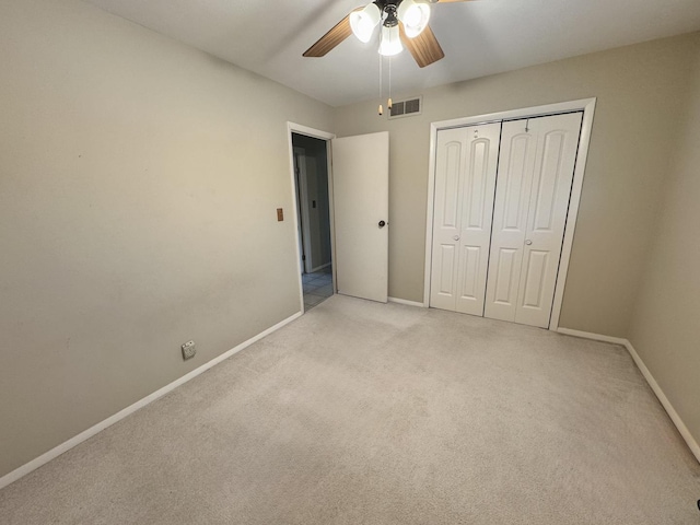 unfurnished bedroom featuring ceiling fan, light carpet, and a closet