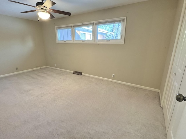 spare room featuring light colored carpet and ceiling fan