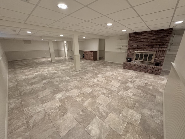 basement featuring a drop ceiling and a fireplace