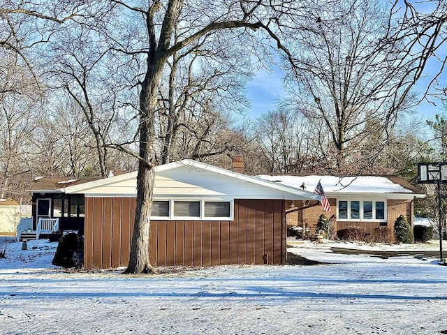 view of snowy exterior with a sunroom