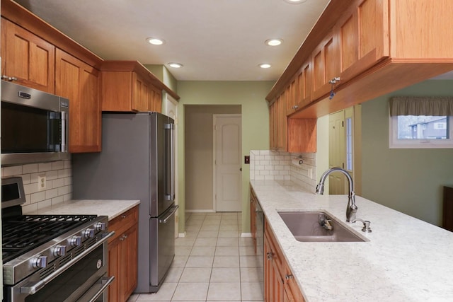 kitchen featuring sink, light stone countertops, light tile patterned floors, tasteful backsplash, and stainless steel appliances