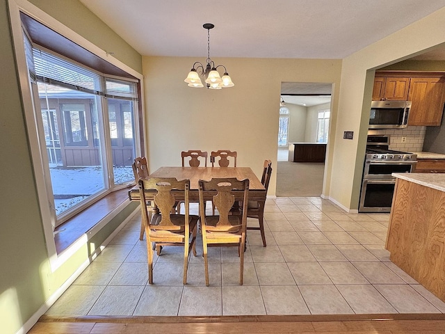 tiled dining room with a chandelier