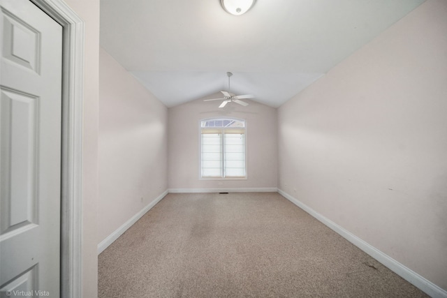 empty room featuring ceiling fan, light colored carpet, and vaulted ceiling