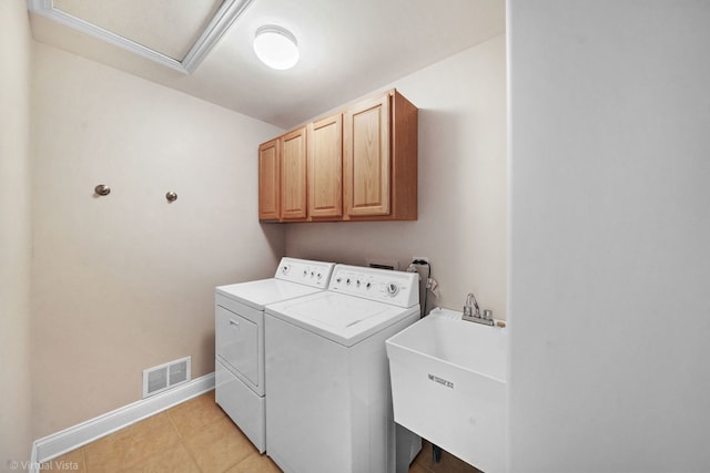 laundry room featuring separate washer and dryer, sink, light tile patterned floors, and cabinets