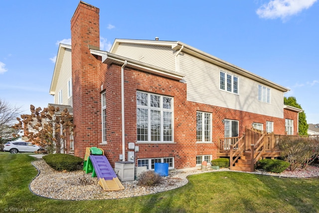 rear view of property with a lawn and a deck